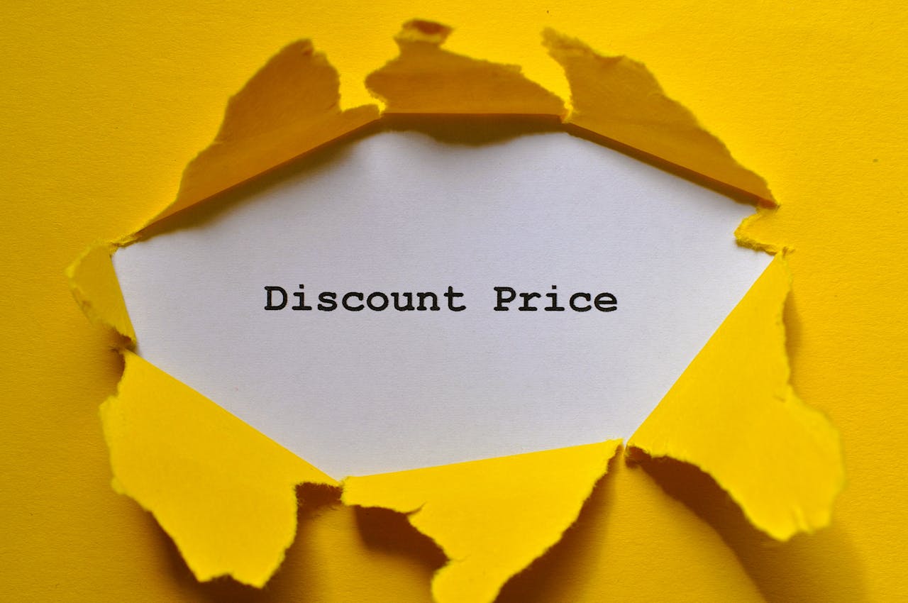 Eye-catching image of torn yellow paper revealing the words Discount Price.